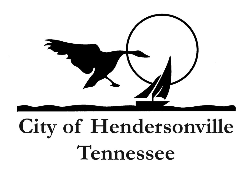Silhouette of a flying bird above a sailboat on water, representing the city of hendersonville, tennessee logo.