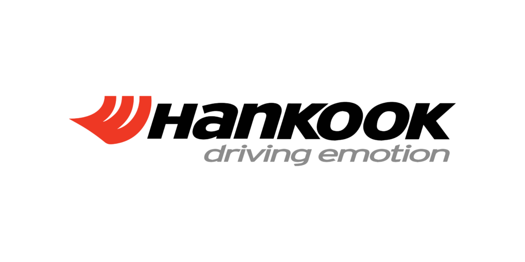 The image shows the logo of hankook tire, featuring a stylized red and orange flame-like symbol to the left of the word "hankook" in bold black lettering, followed by the tagline "driving emotion" in lowercase letters.