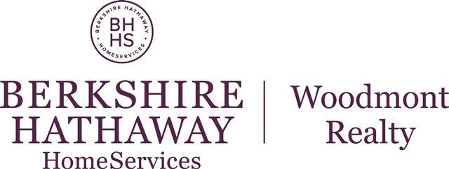 The image displays the logo of berkshire hathaway homeservices along with woodmont realty, indicating a professional partnership or branch related to real estate services.