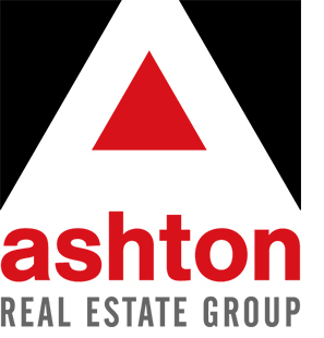 The image shows a logo of "ashton real estate group" with the company name written in black lowercase letters; above the name, there is a stylized depiction of a red triangle, possibly representing a roof or an upward trend, emphasizing their real estate focus.