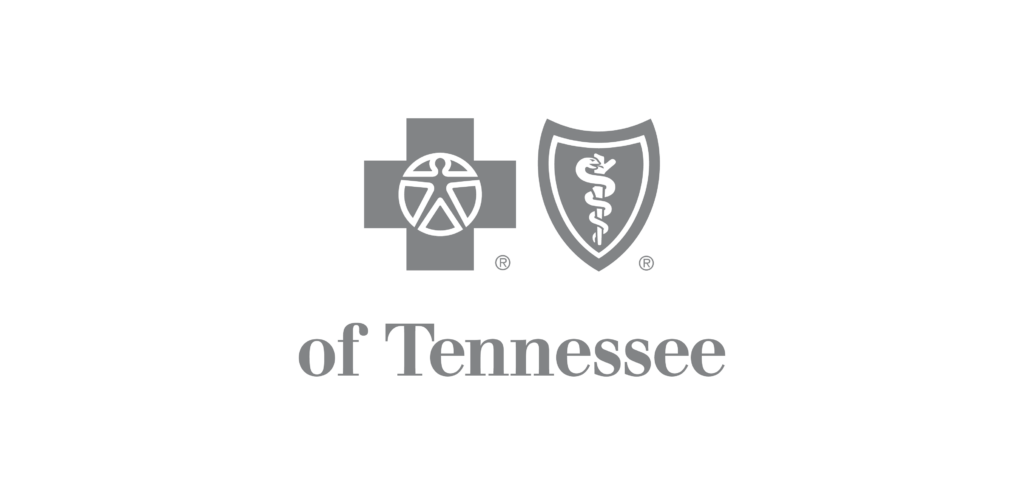 The image depicts a logo with a medical cross featuring a stylized wheel in the center, adjacent to a shield with a caduceus symbol, followed by the words "of tennessee." this suggests the logo represents a medical or health-related organization based in tennessee.