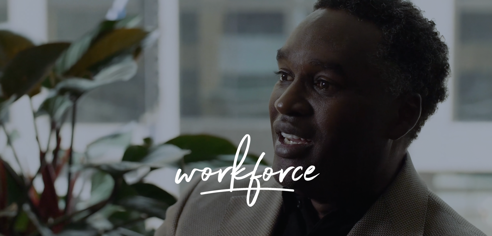 A professional man engaged in a conversation in an office setting with the word "workforce" superimposed on the image, suggesting a theme related to employment, business, or the corporate world.